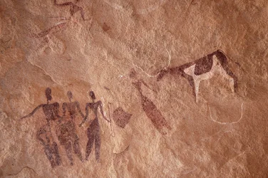 Rock Art, Prehistory: Rock Painting of a Group of Characters and a Two-Tone Cow with Large Horns in an Ornate Shelter, in the Uweinat Massif, Egypt. (Period from 8000 to 3000 years BC). Photography