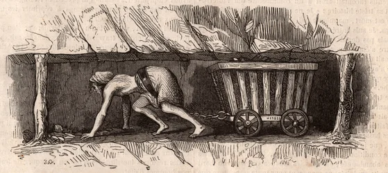 A girl chained to a trolley full of coal and dragging it in an English coal mine