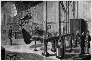 Aerostatic workshop of Tissandier Freres: Overview of a propeller with two helicoidal pallets operated by a Siemens dynamo electric machine and a battery of light potash bichromate batteries. Engraving from 1883. in 