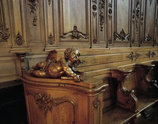 Baroque architecture: wooden stall representing an angel, attribute of the evangelist Saint Matthew. Choir (18th century) of the Church of St. Stephen. Internal view. Marmoutier, Bas Rhin