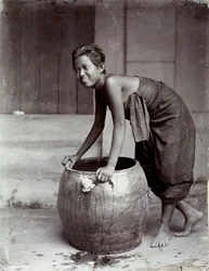 Young smiling Thai woman, pushing a large container