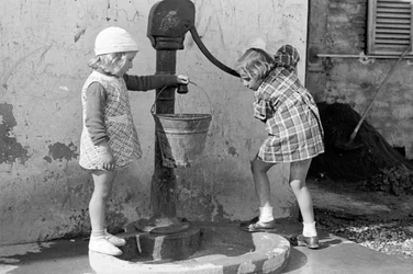 Little Girls Filling a Bucket of Water, 9th May 1939