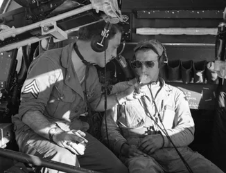 Army Air Corps crew in a B-17 share cigarettes during training at MacDill Field in WWII