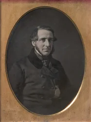 Middle-aged Man with Chinstrap Beard, Hand Tucked Inside Buttoned Jacket