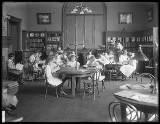 Children reading in the reading room of an unidentified branch of the Queens Borough Public Library, c.1910