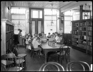 Children reading in the reading room of an unidentified branch of the Queens Borough Public Library, c.1910